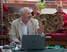 scott gilbert at a computer teaching a lesson to monks and the dalai lama